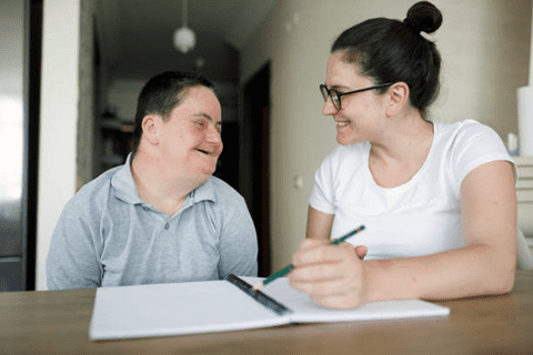 Downs syndrome man with carer